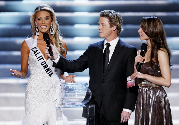 Hosts Billy Bush, center, and Nadine Velazquez, right, listen as Miss California Carrie Prejean, left answers a question from judge Perez Hilton, unseen, about legalizing same-sex marriage during the Miss USA Pageant, Sunday April 19, 2009 in Las Vegas. "We live in a land where you can choose same-sex marriage or opposite marriage," Prejean said. "And you know what, I think in my country, in my family, I think that I believe that a marriage should be between a man and a woman. No offense to anybody out there, but that's how I was raised." (AP Photo/Eric Jamison) Original Filename: Miss_USA_NVEJ114.jpg